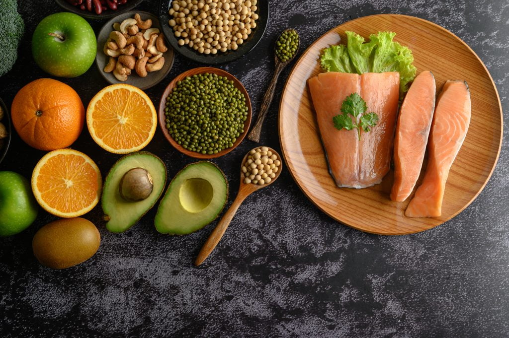 legumes, fruit and salmon pieces on a wooden plate. Food for nail growth